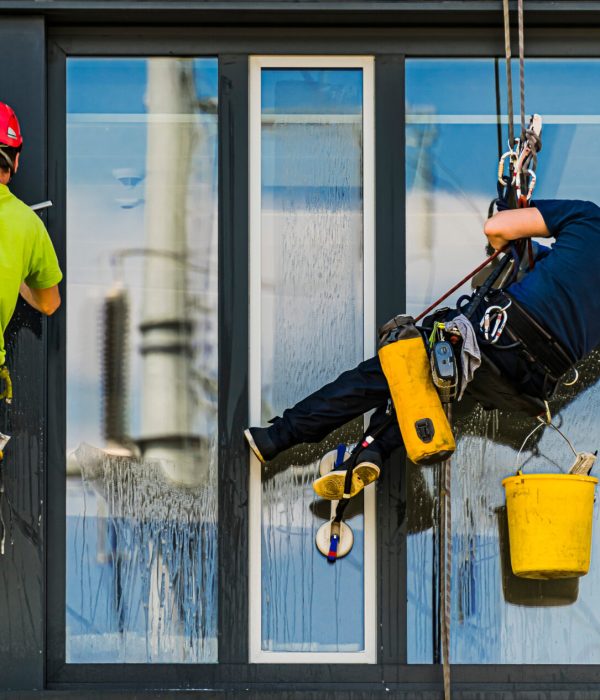 Two men cleaning windows on an office building