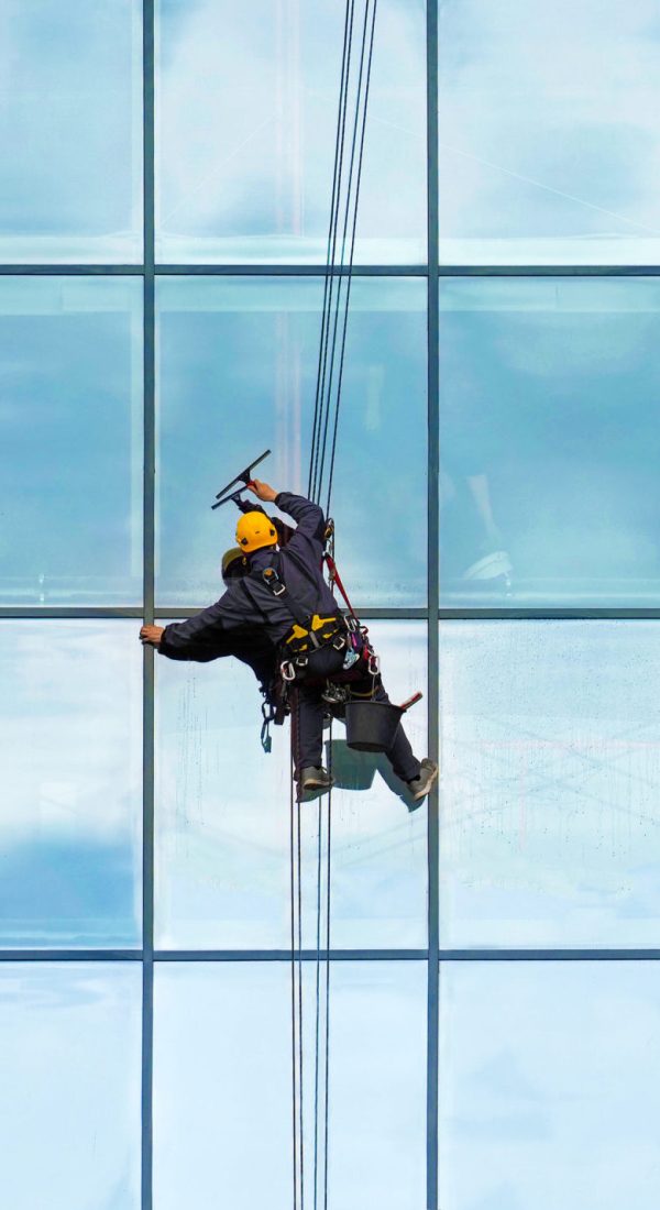 Group of workers cleaning windows service on high rise building. Workers cleaning glass curtain wall. Special job concept, panoramic view